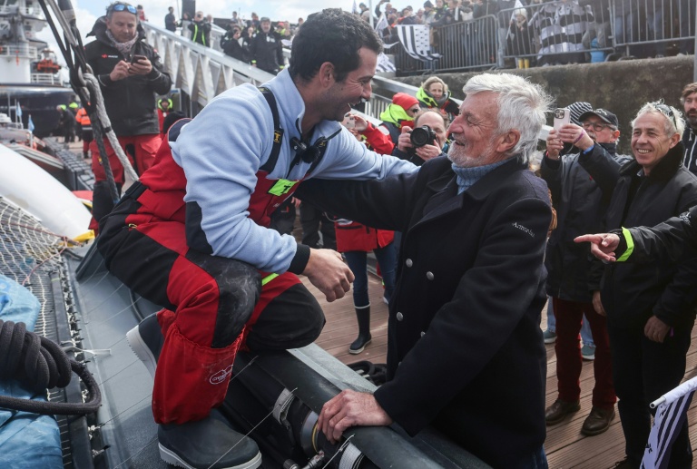 L'aventurier breton Guirec Soudée (G) accueilli à Brest par l'ancien détenteur du record du tour du monde à l'envers, Jean-Luc Van Den Heede (d), le 28 mars 2026