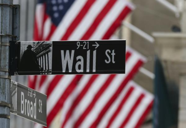 Un drapeau américain derrière un panneau Wall Street le 22 avril 2026 à New York