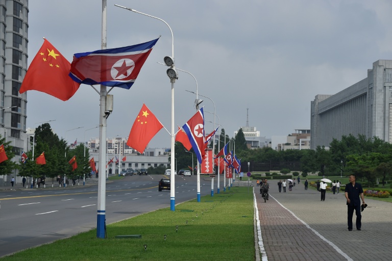 Les drapeaux nationaux de la Corée du Nord et de la Chine flottent dans une rue de Pyongyang le 8 juin 2026