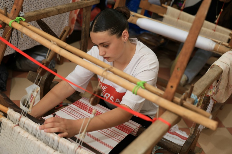 Rozana Gostorani travaille sur un métier à tisser dans un petit atelier à Dajc, dans la région de Zadrima, le 27 mai 2025 en Albanie