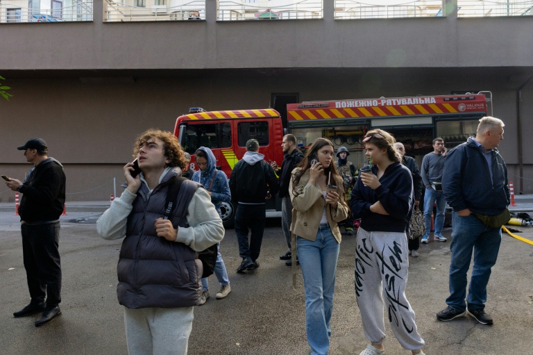 Des habitants observent un immeuble résidentiel endommagé après une frappe de drone russe à Kiev, le 25 septembre 2026