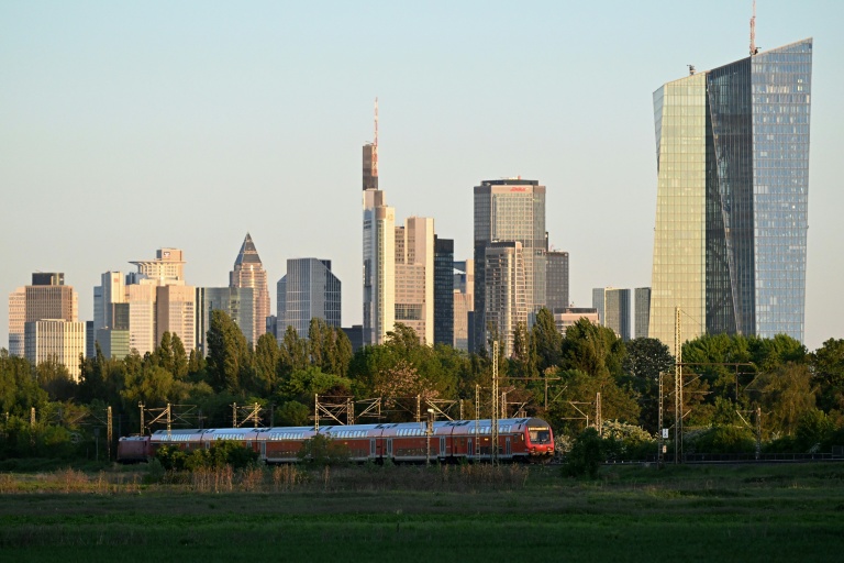 Un train roule près du siège de la Banque centrale européenne (droite) et d'autres immeubles, le 29 avril 2026 à Francfort en Allemagne