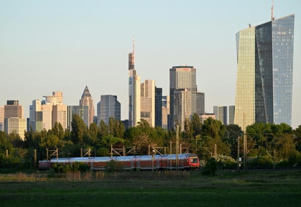 Un train roule près du siège de la Banque centrale européenne (droite) et d'autres immeubles, le 29 avril 2026 à Francfort en Allemagne